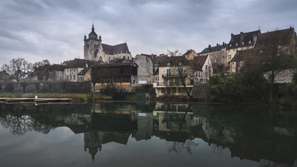 Ancient French classic medieval town with river in front, travel in a cloudy day