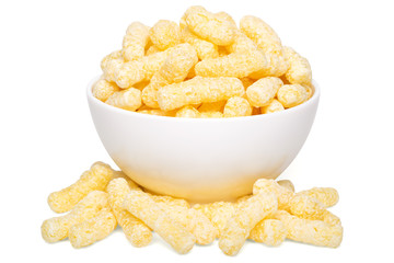 A heap of corn snacks. Sweet sticks of puffcorn. Dry breakfast in white bowl - obrazy, fototapety, plakaty