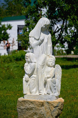 Russia, Kazan June 2019. Statue of a woman with angels made of white stone. Christian sculpture. Religious stone statue.
