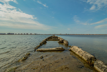 Fototapeta na wymiar Salt lake in a sea resort. A path in the water that leads to the bird's habitat.
