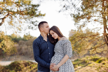 Happy pregnant couple in nature