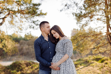 Happy pregnant couple in nature