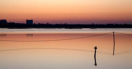 A series of landscapes of a salt lake in a seaside resort after sunset. With reflections.