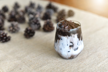 tasty cocoa drink with chocolate dessert bar. Summer refreshment drinks. Chilled iced chocolate cocoa on Sackcloth with Pine cones. top view and Selected focus.