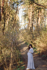 Young pregnant woman relaxing in park outdoors