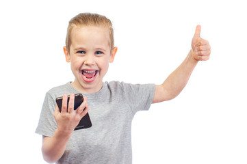 Young smiling caucasian boy with mobile phone shows thumbs up isolated on white background - 353064481