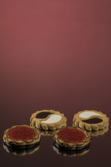 Cake with jam on a red mirror background