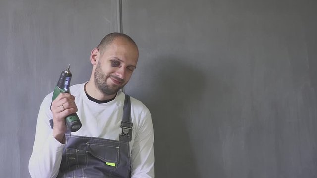 Man with a black eye with a screwdriver in hand