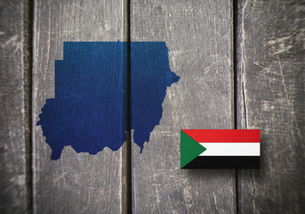 Map and flag of Sudan on a wooden background, 3D illustration