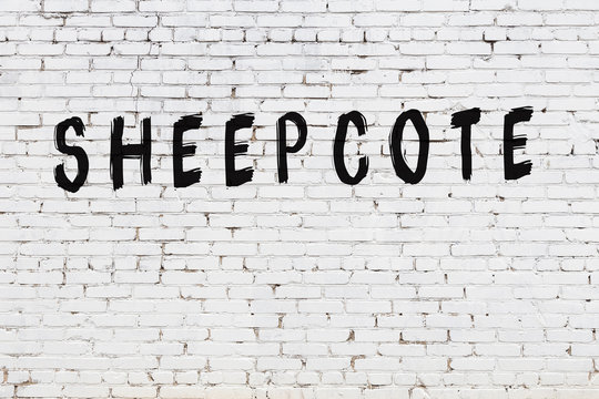 Word sheepcote painted on white brick wall
