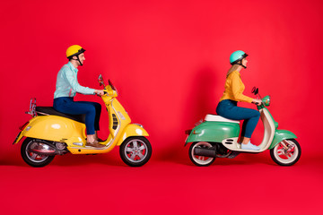 Profile side view of her she his he nice attractive focused cheerful cheery couple driving moped traveling around country isolated on bright vivid shine vibrant red color background