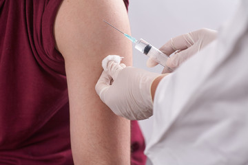 The doctor`s hands are close-up. the doctor gives an injection to the person. Seasonal vaccination. Inoculation. Coronavirus.