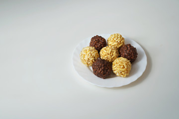  sweet dessert, cakes cake lie on a white plate on a white table stacked on top of each other round shape chocolate and yellow, located on the side, place for the inscription