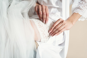 Fototapeta na wymiar Hands of a young bride in a bathrobe. Bride preparation. Getting ready for wedding