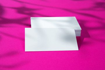 Advertising mock-up. White blank businesscards on bright pink background