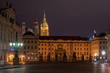 Fototapeta na wymiar Main gate of the Prague Castle by night as seen from Hradcanske Namesti square. 
