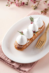 Eclair with currant cream and meringue. Festive atmosphere.