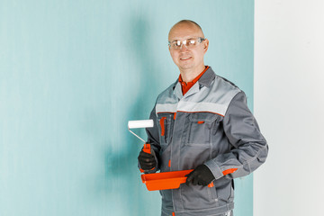 Painting of a young Builder worker with roller at a construction site.