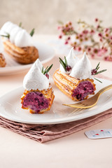 Eclair with currant cream and meringue. Festive atmosphere.