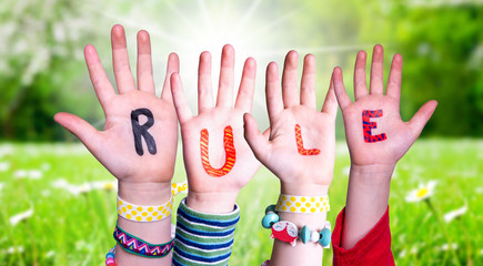 Children Hands Building Colorful Word Rule. Green Grass Meadow As Background