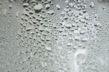 Closeup of beautiful water drops on a clear glass with ice and cold water inside Abstract blurred background and decoration