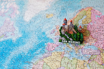 Tourist attractions and souvenir of San Marino on background map of world of puzzles for travelers. Copy space