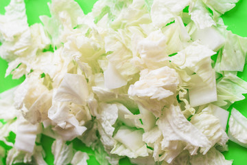 Sliced leaves of Beijing cabbage on a green background. Healthy food. Sliced cabbage.