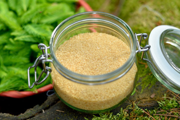 Cane sugar in a retro glass in the woods on a tree stump