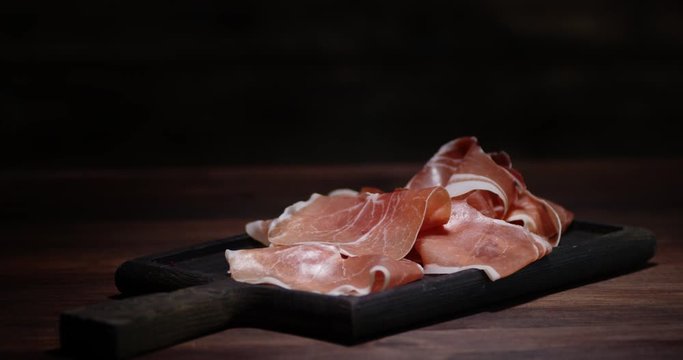 Antipasto slices of meat on cutting Board slowly rotate.