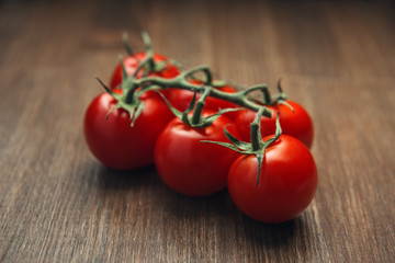 Truss of red cherry tomatoes on the wooden table