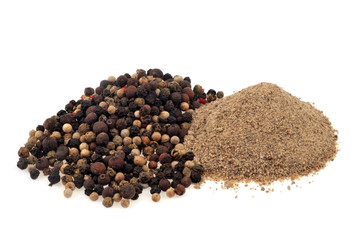 Poivre blanc en poudre et poivre en grains en gros plan sur fond blanc