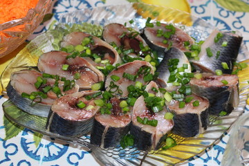 Herring fillet with onion rings on a white plate