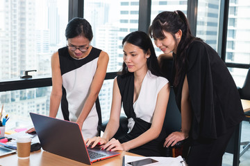 business woman pointing at the laptop screen. talking and gossip colleague