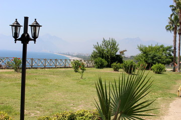 Widok na śródziemne morze w Antalyi. Z tylu góry. Lampy, palmy i krzaki. - obrazy, fototapety, plakaty