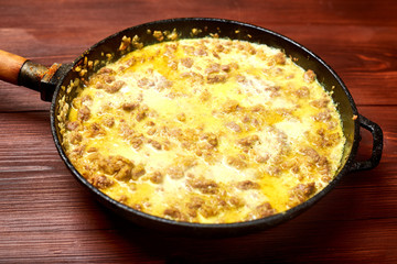 fry, stew minced meat with onions, spices and cream in a pan.