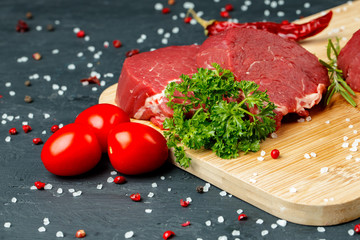 Slice of raw beef fillet on wooden board