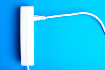 Electrical extension cord, plug and socket on a blue background. The concept of work on...