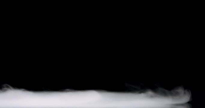 low lying fog rolling in over the bottom of the frame against a black background.
