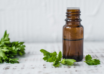 aroma Parsley oil in a dark glass bottle on a white wooden table