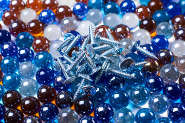 A pile of screws lies on glass balls.