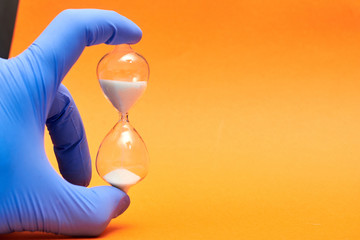 Hourglass in the doctor's hand. Medicine and time concept.