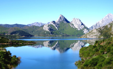 Naklejka na ściany i meble Mountain lake reflection in the reservoir of Riaño