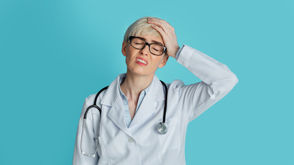 Forgotten and confused concept. Upset doctor closes eyes and press hand to head