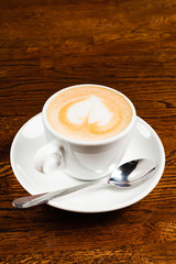 cappuccino with heart shape on the wooden table