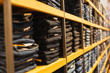shelf with denim pants for sale in a boutique