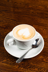 cappuccino with heart shape on the wooden table