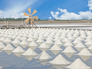 Pile of salt in the salt pan and Wooden Turbine at rural area of Thailand.