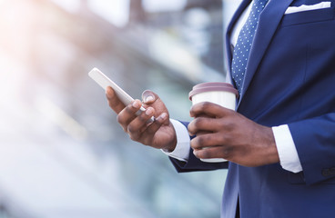 Unrecognizable Businessman Texting On Phone Holding Coffee Standing In City