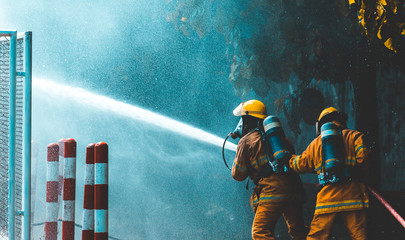 firefighters spray water to wildfire