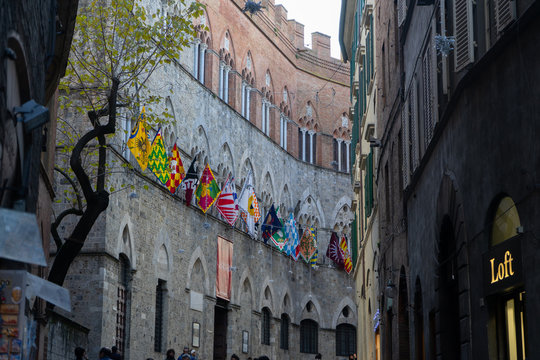 View of a street in town center of Siena with the flags of contrade